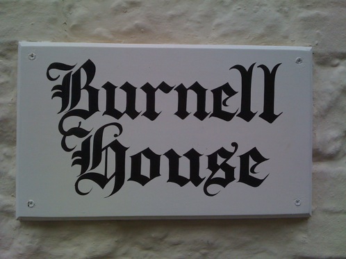 Hand lettered house sign with old english lettering