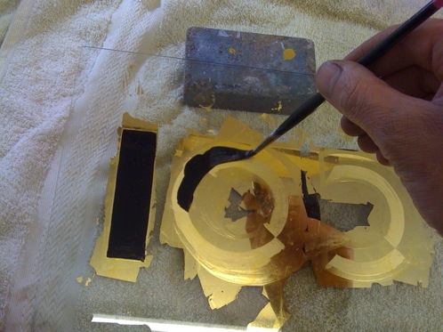 A reverse gold leaf sign on glass in progress