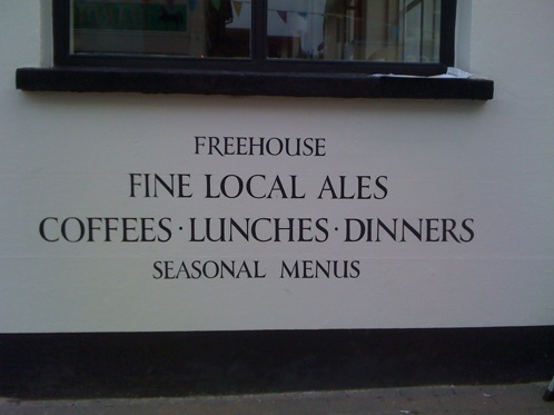 Hand signwritten lettering announce the wares of this traditional pub wall to passers by