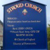 Church notice board with heraldic badge and gold lettering