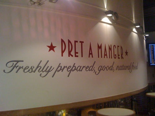 Signwriting to texturesd wall at Pret a Manger, London