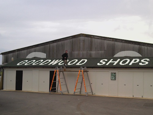 Sign hand painted to the corragated shop roof